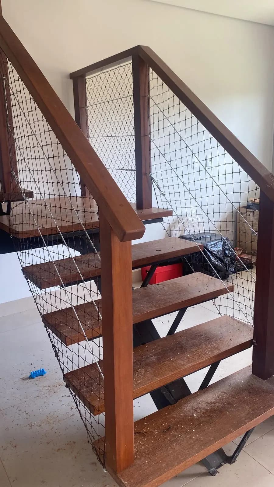 Escada residencial com rede de proteção instalado nas laterais. Segurança em cada degrau.
